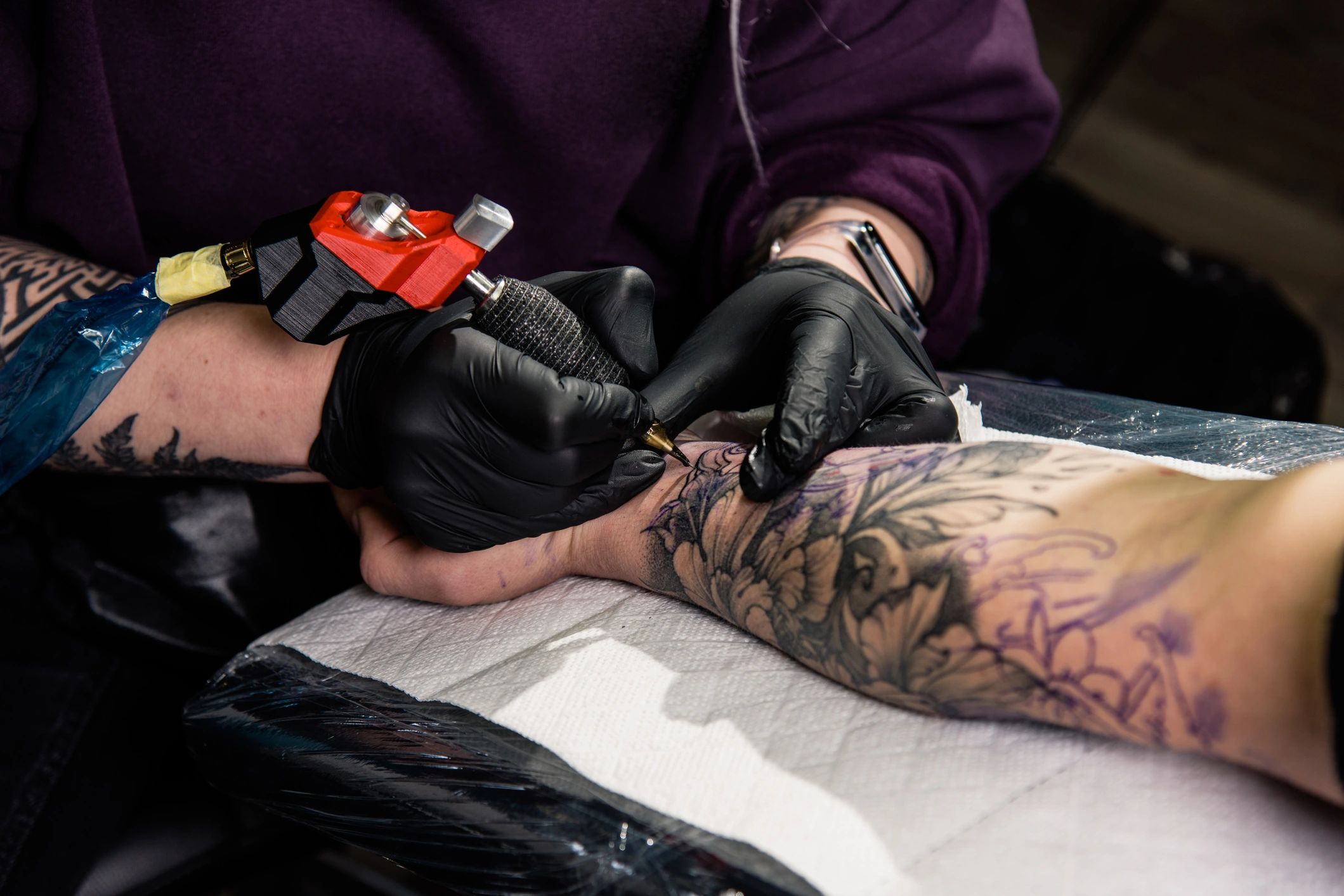 A tattoo artist makes a tattoo in a studio.