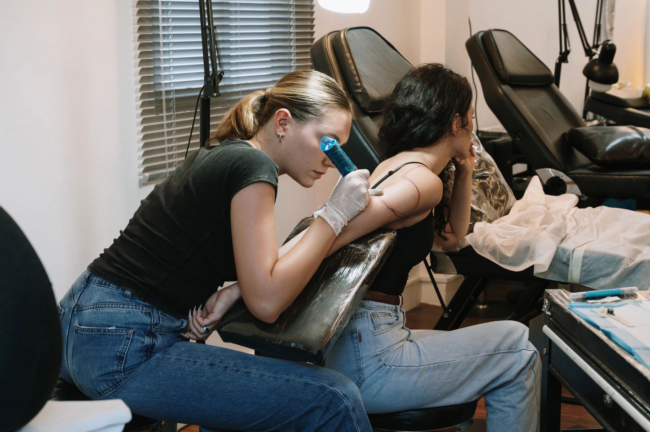 Professional female tattoo artist makes a tattoo on