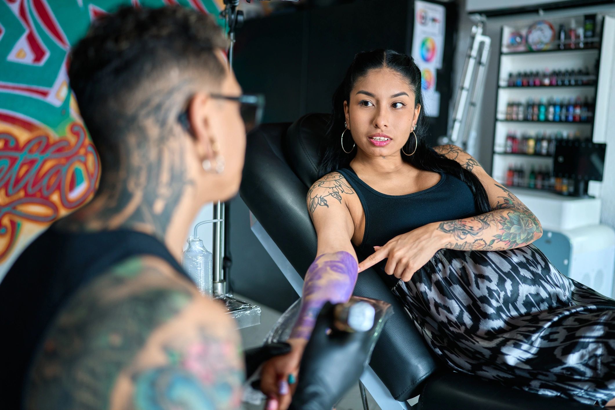 Skilled tattoo artist creating intricate design on client's body